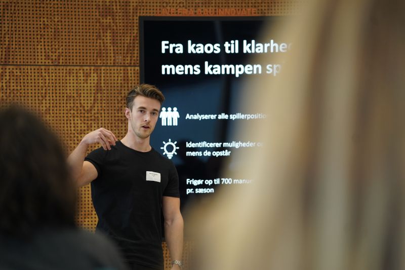 A workshop speaker presenting beside a slide at Pitch Bootcamp.